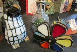 lot 693 image: Stained glass electric penguin,  music box plane missing wing and oil lamp