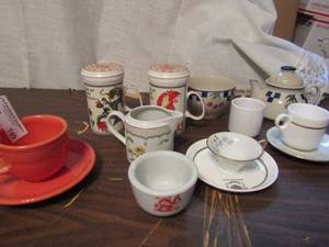 lot 749 image: cup lot- Fiesta orange cup and plate, Dragon cup, Singapore cup and plate cherry teapot and cup
