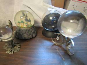 lot 809 image: Lot of 4 glass globes- claw holding sphere, castle snow globe musical, cresant moon plus light up ball