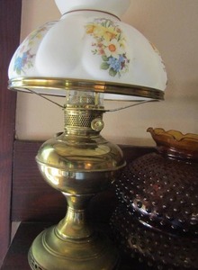 lot 963 image: Victorian oil lamp with gold base and floral design plus extra dark orange Fenton shades