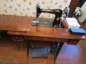 lot 975 image: Singer sewing machine in cabinet some accessories in drawer plus 2 boxes singer sewing machine attachments