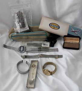 lot 511 image: Watch bands, parts, empty fossil box, souvenir spoon and assorted pieces for repairs.