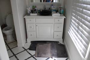 lot 299 image: Bathroom Contents Rugs, Cleaning Wipes, Plug Ins, Lotion and More