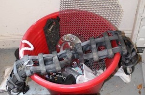 lot 214 image: Misc. Bucket of Items Includes Ford Hubcap, Gerber Sheath, Car Dog Divider