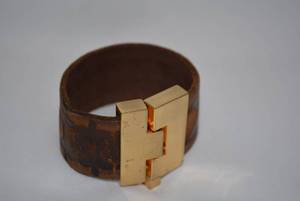 lot 718 image: Signed Leigh Elena Navarro (Austin, TX) exotic leather wide jigsaw H cuff bracelet. Orig retail price $238 Made in USA. Alloy buckle with pin clasp