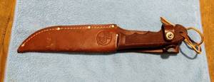 lot 129 image: Red Ryder Bowie Knife with leather sheath, 11 inches in overall length.