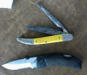 lot 131 image: Two pocket knives, one black handle Stainless China, 7 inches long, the other has a yellow handle, 8 inches long Sabre Japan Needs some TLC, (One Money)