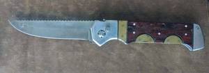 lot 132 image: One Pocket Knife with Strong Spring action, the blade snaps into place, Stainless steel, wood brass handle, heavy, 10 inches total length the blade is 4.5 inches long.