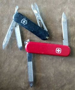 lot 141 image: Two key chain knives one is a Black Victorinox the other a Red Wenger, (One Money)