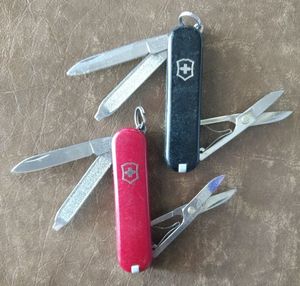 lot 146 image: Two knives Victorinox key chain knives, Red and Black, trust me in that the scissors come in handy. (One Money)