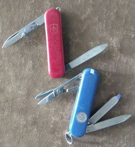 lot 147 image: Two knives Victorinox key chain knives, Blue US Air Force and a Red one,  trust me in that the scissors come in handy. (One Money)