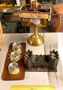 lot 115 image: Distinguished Gentlemans desk items - brass lamp, Weather Station, and wood castle model with knobs