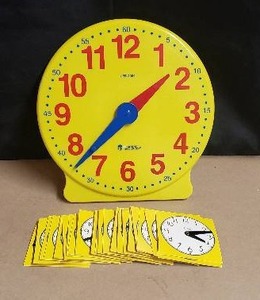 lot 14 image: Learning Resources Teacher Clock with 24 Cardboard Student Clocks