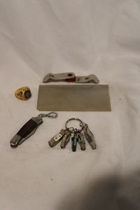 lot 466 image: Folding knives (Jaguar, mini Rough Riders), Quad-Fold folding bottle opener and Big League Chew championship style ring (size 9). Includes knife sharpening stone.