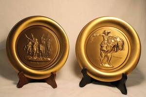 lot 327 image: (2) Frederic Remington 19781979 Bronze collector plates by River Shore Limited from Frederic Remington Museum. Limited to 15,000 edition. Includes (1) Bronco Buster (#3193), (1) Coming Through the Rye (#2685) .  7.75W w stands