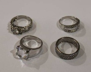 lot 390 image: (4) rings. 2-Sterling silver and CZ rings Marled 925 CZ (Both size 10) and 2- unmarked white metal rings (Sizes 9 and 10)