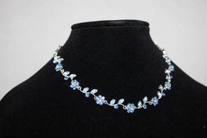 lot 373 image: White metal and blue glass delicate floating necklace in flower form links. Chromium anti tarnish finish. 14L w 2 extender chain. Has metal jewelry tag but unknown maker. No markings.