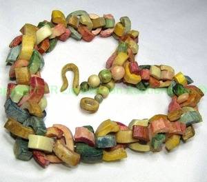 lot 114 image: Substantial statement dyed and carved camel bone necklace. Featuring classic traditional fuschia, green, red, gold colors. 22L w shepherds crook clasp.