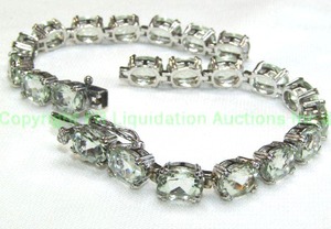 lot 24 image: Sterling silver and Aquamarine prong set tennis bracelet. Marked 925. Hidden clasp with 2 safety clasps. Broken. Approx 33 cttw Aquamarines. 9L