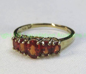 lot 129 image: 10K yellow gold and Orange Sapphire ring. Marked 10K. Size 7.25