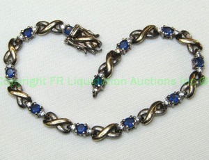 lot 425 image: Sterling silver Sapphire and Diamond simulant (glass) X and O two tone bracelet. Marked 925. Clasp needs attention