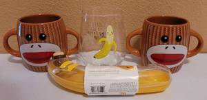 lot 230 image: (2) GALERIE CANDY DOUBLE HANDLED SOCK MONKEY CUPS 4H x 7W, BANANA KEEPER (NEW) AND BANANA WINE GLASS