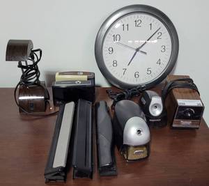 lot 20 image: MIXED LOT INCLUDING WALL CLOCK, PAPER HOLE PUNCHERS, PENCIL SHARPENERS, AND LAMP AS SHOWN.