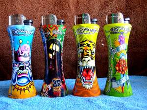lot 32 image: ED HARDY JUMBO CURVE Refillable LIGHTERS - COLLECTION OF 4 - WITH BOTTLE OPENER