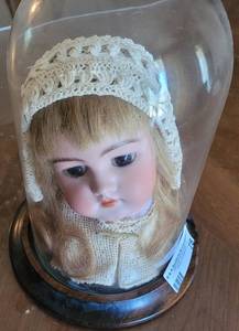 lot 78 image: RARE DOLL MADE WITH REAL HAIR IN THE EARLY 1900S. LACE CAP CROCHETED IN 1932. INCLUDED WOOD BASE AND GLASS DISPLAY.