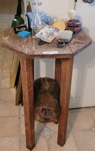 lot 287 image: OCTAGONAL RUSTIC WOOD-STYLE ACCENT TABLE WITH CONTENTS SHOWN.