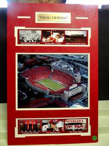 lot 37 image: NEBRASKA CORNHUSKERS WALL DISPLAY - DOUBLE MATTED WITH METAL PLATE AND HISTORY PHOTOS