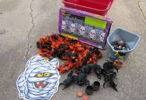 lot 13 image: Halloween Decorations, 2 boxes of skull fence, garland, fake spiders, orange candles, Mini tin pumpkins