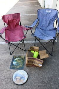 lot 175 image: Folding Lawn Chairs, Metal Welcome to the Cabin Sign, Partial box of Clay Pigeons, and Elk Wall Thermometer