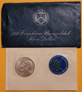 lot 63 image: 1973 EISENHOWER UNCIRCULATED SILVER DOLLAR IN SEALED PACKAGE AS SHOWN.