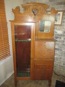 lot 81 image: ANTIQUE OAK GUN SAFE CABINET, LOCKS WITH KEY 36 X 12 X 72. HOLDS 5 GUNS, HAS STORAGE AND MIRROR