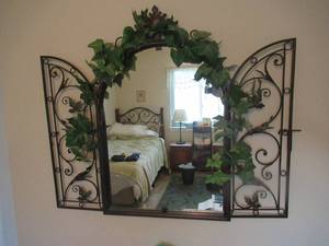 lot 162 image: MIRROR WITH FAUX FLOWERS 43 X 37,  METAL 3 TIER MAGAZINE RACK 36 AND 2 NIGHT STAND LAMPS THAT ARE ADJUSTABLE 27