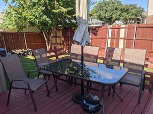 lot 9 image: Aluminum Patio Table with Glass Top and Six Chairs. The table is 63 inches long by 38 inches wide and 28inches tall.
