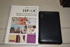 lot 98 image: Hewlett-Packard 12-C Calculator and Guide Book