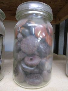 lot 241 image: GLASS JAR FILLED WITH SMOOTH ROCK BEADS