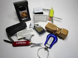 lot 98 image: 2 MLRS ZIPPOS, LOCKEED MARTIN ZIPPO COVER,SWISS ARMY KNIVES, LOCKHEED MARTIN TOY TRUCK