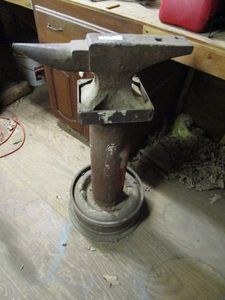 lot 114 image: LARGE &amp HEAVY ANVIL, MOUNTED TO LG PIPE AND CEMENTED IN CAR RIM