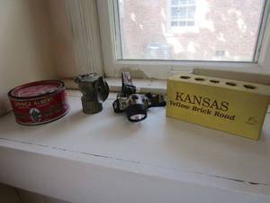 lot 295 image: ANTIQUE EARLY 1900s CARBIDE MINERS LIGHT, PRINCE ALBERT TABBACCO CAN, CAMO MODERN HEADLAMP, KANSAS YELLOW BRICK ROAD BRICK- AS COLLECTION