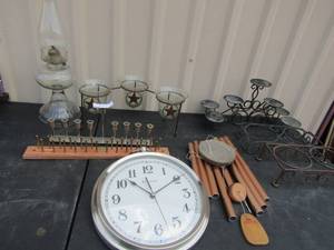 lot 41 image: 10 oval  wall clock, 2 metal cookware racks, copper wind chimes and 7 tier candle holder