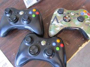 lot 106 image: 2 black Playstation controls     1 CAMO X-box 360 series control