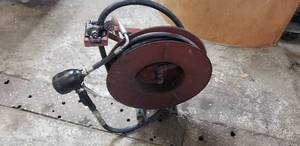 lot 1052 image: Reelcraft Retracting Hose Reel w 34 Oil Hose, Meter Gauge Gun & CeilingWall Mount