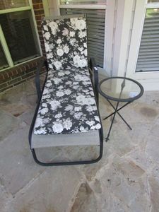 lot 96 image: OUTDOOR SUN LOUNGER WITH FLORAL PATTERN CUSHIONS, CROSS HATCH SNACK TABLE W GLASS TOP &amp FLEUR-DE-LIS AT LEG ENDS