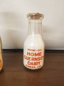lot 28 image: Home Guernsey Dairy - Eureka, California -  pint glass milk bottle with lid