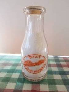 lot 31 image: Poinsettia Dairy Products pint glass milk bottle with lid