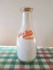 lot 60 image: Lotus Lawn Dairy -Oshkosh quart glass milk bottle with lid