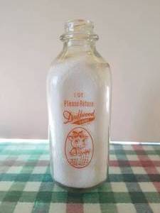 lot 72 image: Driftwood Dairy quart glass milk bottle with lid